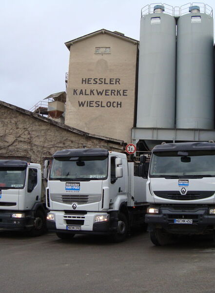 LKW-Flotte vor dem Werk der Hessler Kalkwerke mit Silos und Verladebereich