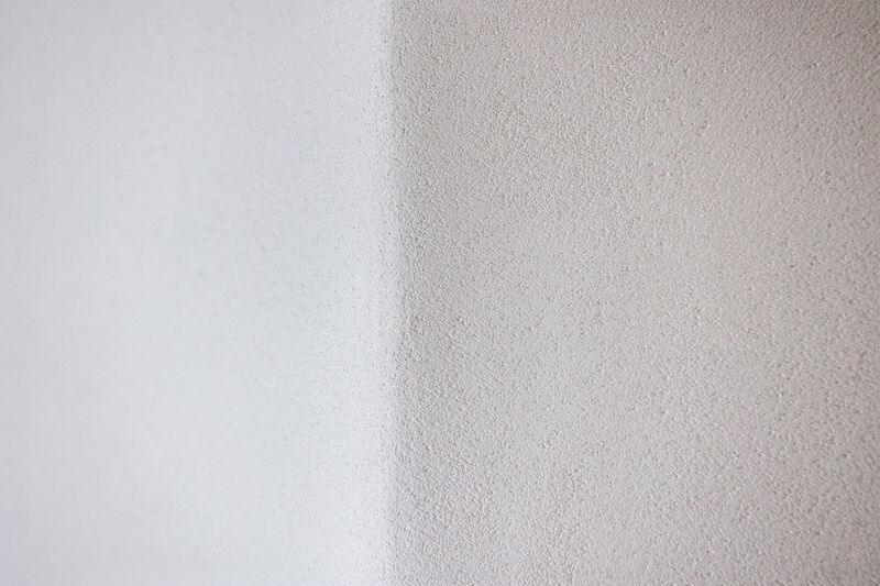 Detailaufnahme einer Naturkalkputz-Oberfläche in Weiß und Beige mit feiner Struktur